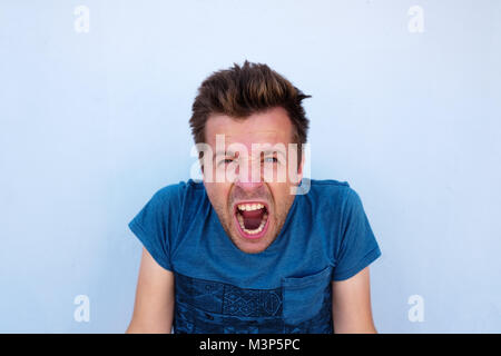 Verzweifelte Wut tobte Mann im blauen Hemd schreien laut seine Augen voller Zorn in Stockfoto