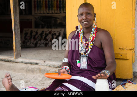 KIWENGWA, SANSIBAR - Dec 26, 2017: Lokale Frau arbeitet an einem Souvenirs vor ein Tourist shop in Kiwengwa Dorf, Sansibar Stockfoto