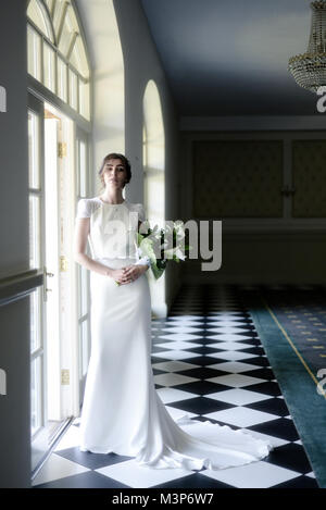 Eine schöne dunkelhaarige Braut tragen eine teure Hochzeit Kleid an einem sonnigen Tag - Hell Stockfoto