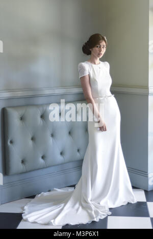 Eine schöne dunkelhaarige Braut tragen eine teure Hochzeit Kleid an einem sonnigen Tag - Hell Stockfoto