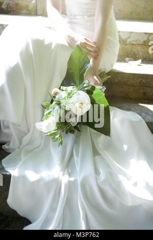 Eine schöne dunkelhaarige Braut tragen eine teure Hochzeit Kleid an einem sonnigen Tag - Hell Stockfoto