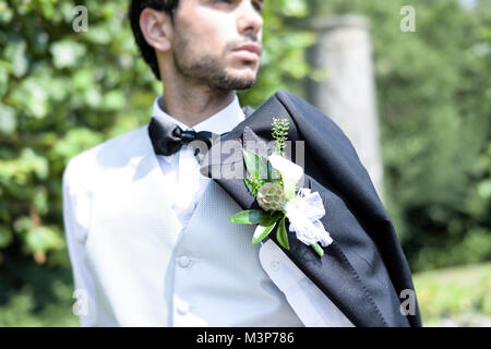 Porträt einer hübschen dunkelhaarigen jungen Mann Hochzeit Kleidung auf einem hellen, sonnigen Tag, blickt er zuversichtlich und fröhlich Stockfoto