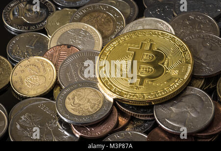 Golden bitcoin über einem Haufen verschiedener Münzen. Stockfoto