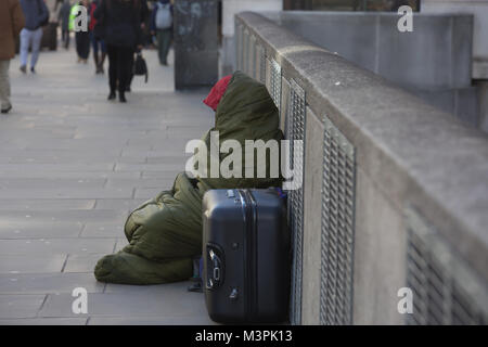 London, UK, 12. Februar 2018, eine obdachlose Person sitzt warm eingepackt mit Schlafsack gegen das kalte Wetter © Keith Larby/Alamy leben Nachrichten Stockfoto