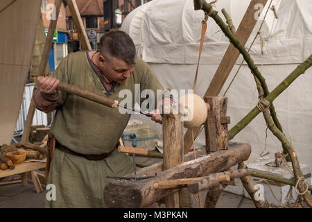 York, UK, 12. Februar 2018. Person gekleidet wie ein Wikinger auf der jährlichen Jorvik Viking Festival in der Innenstadt von York statt. Dieser Mann ist ein erfahrener Drechsler & ist die Konzentration auf Handarbeit eine hölzerne Schüssel, mit einem einfachen Drehbank & handgefertigte Werkzeuge. Er beteiligt sich an der realistischen Re-enactment von Leben bei einem Viking Markt. North Yorkshire, England, UK. Credit: Ian Lamond/Alamy leben Nachrichten Stockfoto