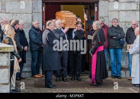 Öfen, Irland. 12 Feb, 2018. Die Beerdigung von spielergebnissen Liam Miller nahm heute am St. Johannes der Täufer Kirche, Öfen, County Cork, Irland, statt. Eine große Anzahl von Trauernden nahmen an der Beerdigung, darunter viele Fußballer und Manager aus alten Miller's Clubs, darunter die Stadt Cork, Keltische und Manchester United. Bischof John Buckley besprüht heiligen Wasser über Liam Miller's Sarg nach dem Begräbnis. Credit: Andy Gibson/Alamy Leben Nachrichten. Stockfoto