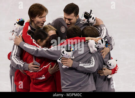 Gangneung, Südkorea. 12 Feb, 2018. Olympischen Athleten aus Russland Alexander Enbert und Wladimir Morosow hug Teamkollegen Michail Kolyada, Evgenia Medvedeva, Alina Zagitova, Evgenia Tarasova, Natalia Zabiialo, Dmitri Soloviev und Ekaterina Bobrova feiert die Silbermedaille im Eiskunstlauf Team Event bei der PyeongChang 2018 Winter-olympischen Spiele bei Gangneung Ice Arena am Montag, den 12. Februar 2018. Credit: Paul Kitagaki jr./ZUMA Draht/Alamy leben Nachrichten Stockfoto