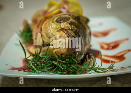 Fisch mit Zitrone Keile und eine grüne Rosmarin. Geringe Tiefenschärfe. Stockfoto