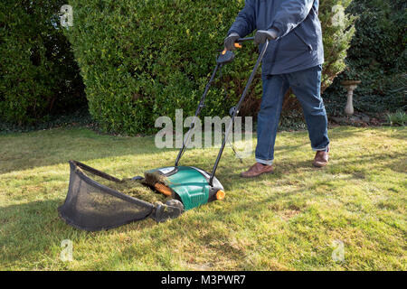 Gärtner mit einem elektrischen Garten Rasenlüfter. Stockfoto