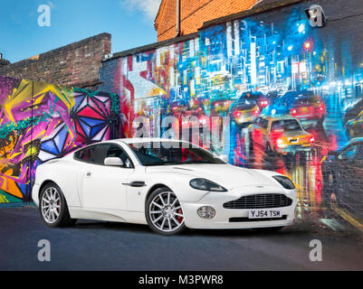 2004 Aston Martin Vanquish von Street Art in Camden Town North London UK geparkt Stockfoto