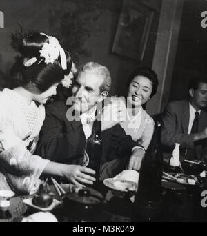 1950, historische, einem westlichen Gentleman ein Getränk von einer japanischen Geisha Girl in eine Hostess Bar, Tokio, Japan serviert wird. Stockfoto