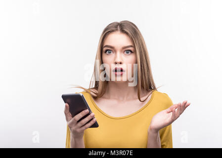 Hübsche Frau auf der Suche nach dem Lesen der Nachricht überrascht Stockfoto