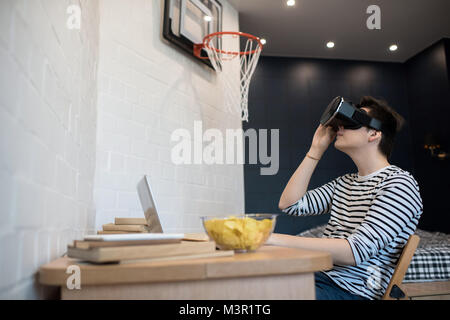 Junge Mann spielt VR-Spiel Stockfoto