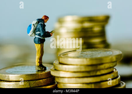 Nahaufnahme von einer Miniatur traveler Mann, der einen Rucksack, auf einem Stapel von Euro-Münzen Stockfoto