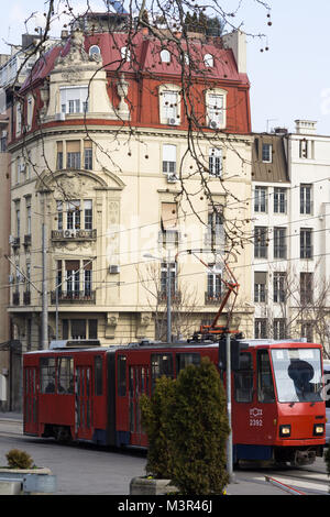 Ein Gebäude mit rotem Dach und eine alte rote Straßenbahn in Belgrad, Serbien. Stockfoto