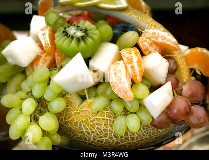 Große Kürbis, in Form von einem Korb dekoriert und mit einer Vielzahl von Früchten gefüllt: Trauben, Kiwi, Bananen, Mandarinen Stockfoto