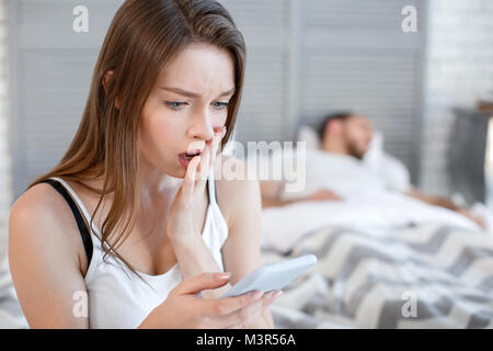 Unglückliche Frau lesen ihre Botschaften mans Stockfoto