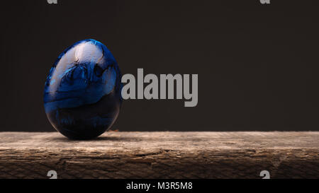 Blaues Osterei auf einem rustikalen Holztisch mit Platz für Text oder Bild, Frohe Ostern Hintergrund Stockfoto