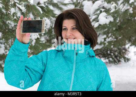 Eine Frau, die ein salfi in einem verschneiten Wald Stockfoto