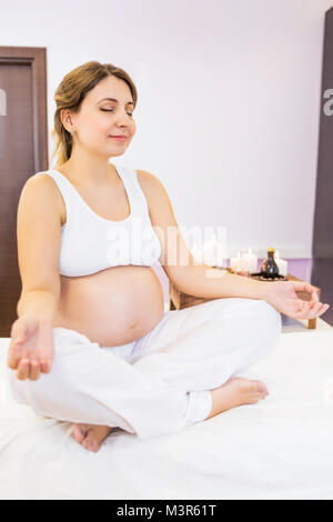 Portrait des jungen schwangeren Yoga zu Hause Stockfoto