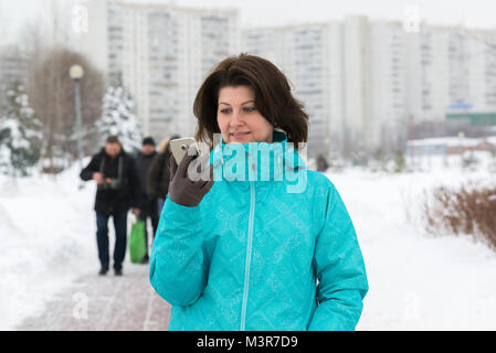 Frau schaut auf dem Telefon in der Stadt Moskau, Russland Stockfoto