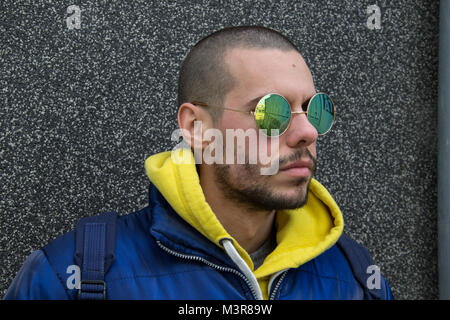 Porträt eines jungen Mannes in einem blauen Jcket mit gelben Haube Stockfoto