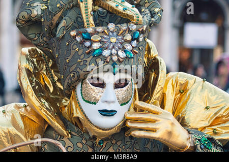 Porträt eines Mannes Tragen eines weißen und grünen Maske während des Venezianischen Karnevals party in San Marco Platz Stockfoto