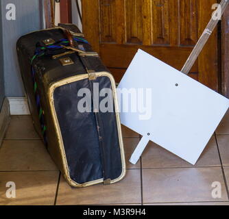 Warnen, Retro alte Pappe Koffer und eine leere weiße Sicherheitsplakette außerhalb eine offene Tür Bild im Querformat. Stockfoto