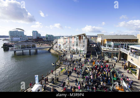 Eine allgemeine Ansicht der Mermaid Quay in Cardiff Bay an einem warmen sonnigen Tag mit blauen Himmel in Cardiff, South Wales, UK. Stockfoto