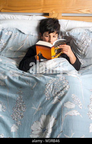 Junge lesen Buch im Bett, Harry Potter von J.K.Rowling, Großbritannien Stockfoto