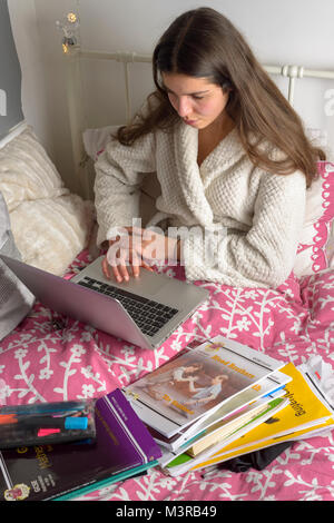 Junges Mädchen, 15-16 Jahre alten Studien im Bett - close-up, Surrey, Großbritannien Stockfoto