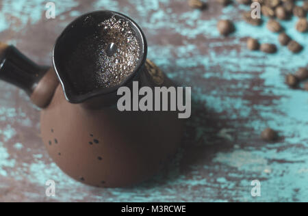 Ein cezve ist ein Topf türkischer Kaffee und Kaffeebohnen auf blauem Hintergrund zu machen Stockfoto