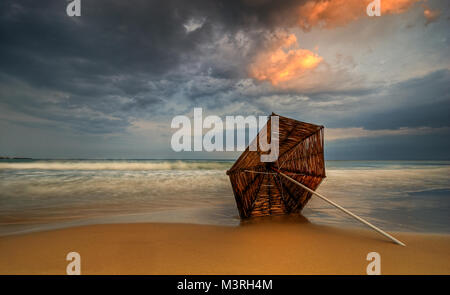 Die gefallenen Regenschirm - Nach dem schweren Sturm die Sonne durch die Wolken bricht Stockfoto