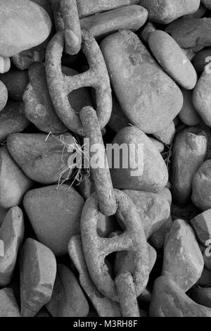 Schwarzweiß-Foto von einem alten Anker Kette in Flechten auf Pebble Beach. Stockfoto