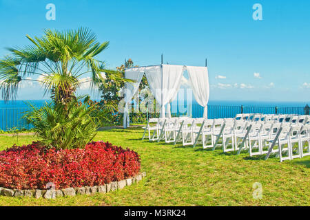 Weißen Stühlen und Bogen für die Trauung auf der Terrasse mit Meerblick auf sonnigen Sommertag in Ravello, Amalfi, Italien vorbereitet Stockfoto