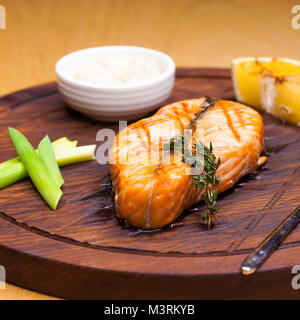 Glasierte Lachsfilet mit Sesam close-up auf einer Holzplatte Stockfoto