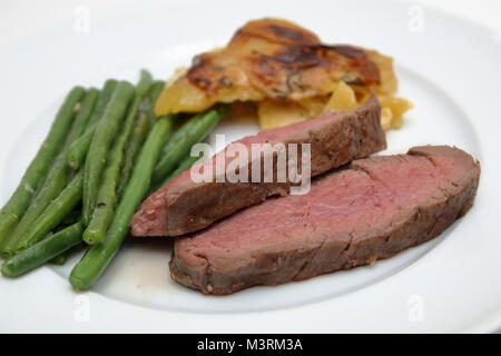 Rinderfilet mit Kartoffelgratin und Bohnen Stockfoto