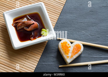 Liebe Sushi abstrakte Menü Konzept mit nigiri Herz auf schwarzem Hintergrund Stockfoto