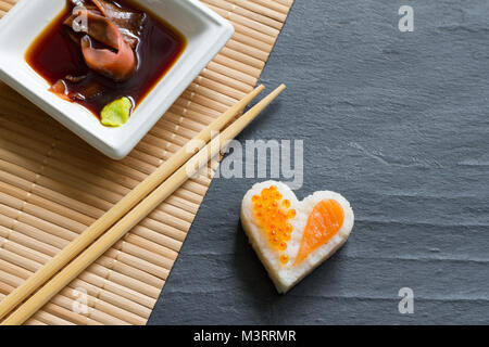 Liebe Sushi abstrakte Menü Konzept mit nigiri Herz auf schwarzem Hintergrund Stockfoto