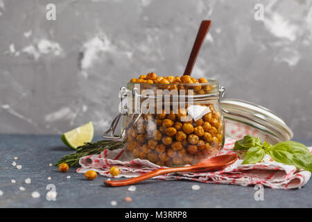 Gesunde Snack - gebackene würzige Kichererbsen in Glas. Gesunde vegane Ernährung Konzept. Stockfoto