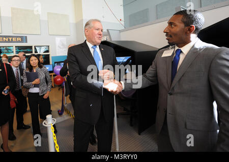 Der Herr Abgeordnete Frank Kendall, unter Verteidigungsminister für Beschaffung, Technik und Logistik, grüßt Herr Brian Johnson, Lehrer, TransStem Akademie am FLEX-ACE LAB Ribbon Cutting an Francis L. Cardozo Ausbildung Campus, Washington, D.C., September 20th, 2015 statt. Flexible Aviation Unterricht (FLEX-ACE) erstellt ein immergence in Wissenschaft, Technologie, Ingenieurwesen und Mathematik (STEM) pädagogischen Umfeld. Die FLEX-LAB repliziert Test Range Control Room und Operations Center mit modernsten Computern, Flugsimulatoren, und Air Traffic Control Tower. Die FLEX - ACE Stockfoto