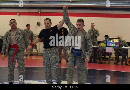 Us-Armee Master Sgt. Richard Silva (Mitte), eine Armee Kursleiter combatives, hebt die Hand des Airman 1st Class Brian Baker (rechts) nach dem Gewinn einen Zeitraum während der 7. Mission zu unterstützen Befehle (MSC) Army Combatives Turnier am Kleber Kaserne, Deutschland am Dez. 4, 2015. Das Turnier gab Soldaten und Piloten die Möglichkeit, voneinander zu lernen und ihre combatives Fähigkeiten gegen andere Mitbewerber. (DoD Nachrichten Foto durch TSgt Brian Kimball) 151204-F-QP 401-084 von DoD News Fotos Stockfoto