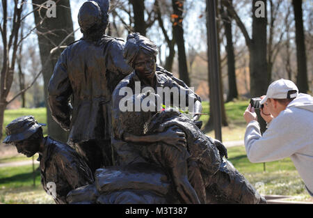 - Besucher und Touristen in Scharen zur National Mall, Memorial Statue die Vietnam Women's auf nationalen Vietnam Veterans Day zu besuchen. Die Statue auf der National Mall in Washington D.C. in der Nähe von Mauer der Erinnerung der Vietnam Veteran befindet. Die Vietnam Women's Memorial ist ein Denkmal für die Frauen in den Vereinigten Staaten, die im Vietnam Krieg diente, von denen die meisten waren Krankenschwestern gewidmet. Es dient als Erinnerung, die Bedeutung der Frauen in den Konflikt. Es zeigt drei Uniformierten Frauen mit einem verletzten Soldaten. Es ist Teil des Vietnam Veterans Memorial, und ist auf der National Mall in Washington D.C., ein s Stockfoto