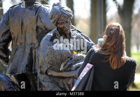 - Besucher und Touristen in Scharen zur National Mall, Memorial Statue die Vietnam Women's auf nationalen Vietnam Veterans Day zu besuchen. Die Statue auf der National Mall in Washington D.C. in der Nähe von Mauer der Erinnerung der Vietnam Veteran befindet. Die Vietnam Women's Memorial ist ein Denkmal für die Frauen in den Vereinigten Staaten, die im Vietnam Krieg diente, von denen die meisten waren Krankenschwestern gewidmet. Es dient als Erinnerung, die Bedeutung der Frauen in den Konflikt. Es zeigt drei Uniformierten Frauen mit einem verletzten Soldaten. Es ist Teil des Vietnam Veterans Memorial, und ist auf der National Mall in Washington D.C., ein s Stockfoto