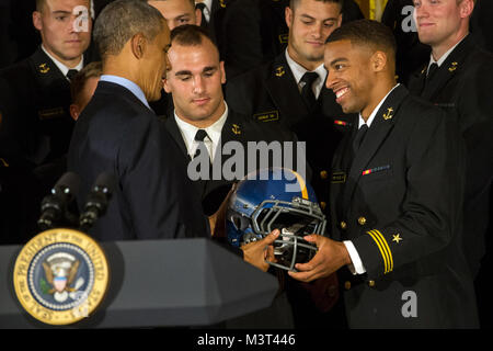 Us Naval Academy Co - Kapitän und College rekordverdächtige quarterback Keenan Reynolds, rechts, stellt Präsident Barack Obama mit einem Team Helm während der Commander in Chief's Trophy Preisverleihung im Weißen Haus in Washington, D.C., 27. April 2016. Der Präsident präsentiert die Trophäe zu Verteidigungsministerium Akademie Team mit den meisten Siegen gegen seine Rivalen. (DoD Nachrichten Foto durch EJ Hersom) 160427 - D-DB 155-006 von DoD News Fotos Stockfoto
