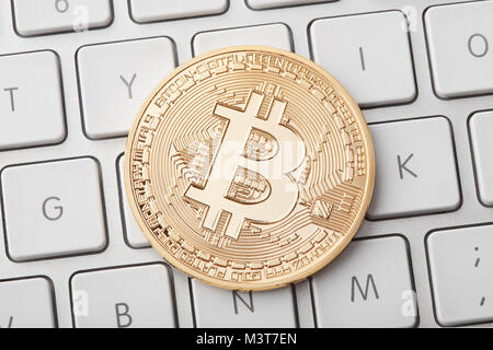 Einen goldenen Bitcoin auf weiße Tastatur, Freistellungspfad Stockfoto