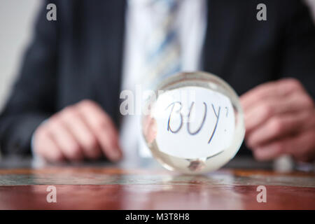 Nahaufnahme der Mann hält Papier mit Word vor Glaskugel kaufen Stockfoto