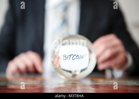 Nahaufnahme der Mann hält Papier mit Word Bitcoin vor glas kugel Stockfoto