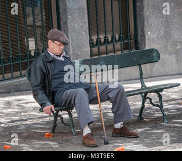 Älterer Herr, der eine Siesta am Nachmittag auf einer Bank in Funchal Madeira nimmt Stockfoto