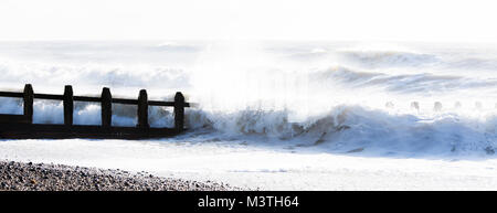 Eine Welle Spritzen gegen einen wellenbrecher am Strand von Littlehampton, West Sussex Stockfoto